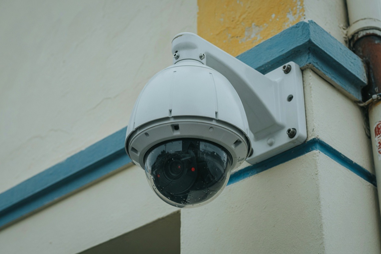 White PTZ dome camera on the corner of a building